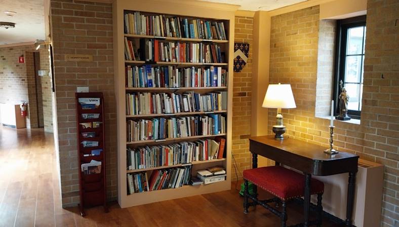 A room with a bookcase and a desk

Description automatically generated